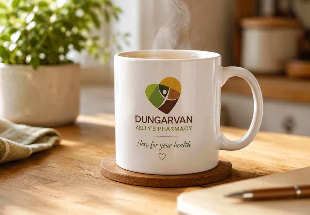Dungarvan Kelly's Pharmacy mug with "Here for your health" tagline on a wooden table